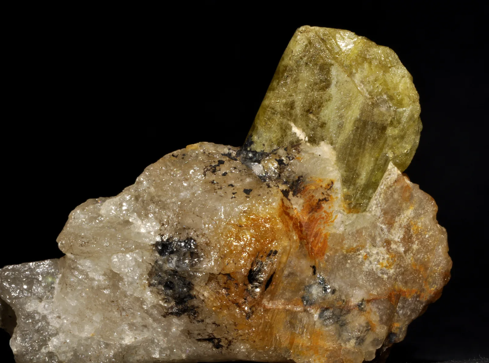 Cluster of alexandrite crystals from Madagascar, green in natural light, on a pale ground