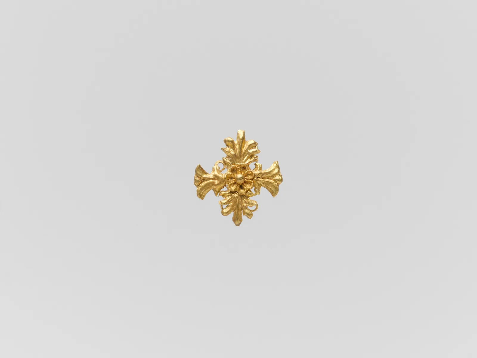 Ancient gold quatrefoil ornament with palmette arms and a small central rosette