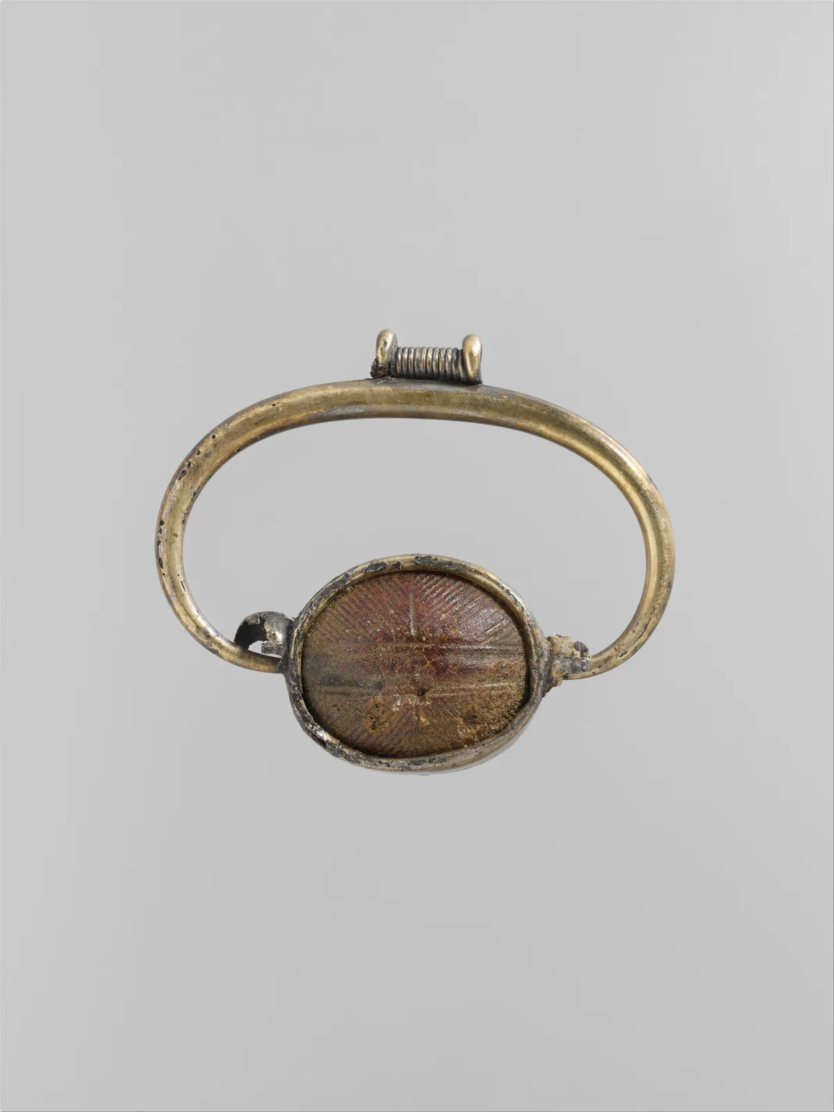 Etruscan silver-gilt pendant set with a warm honey-colored amber pane, the resin already the face