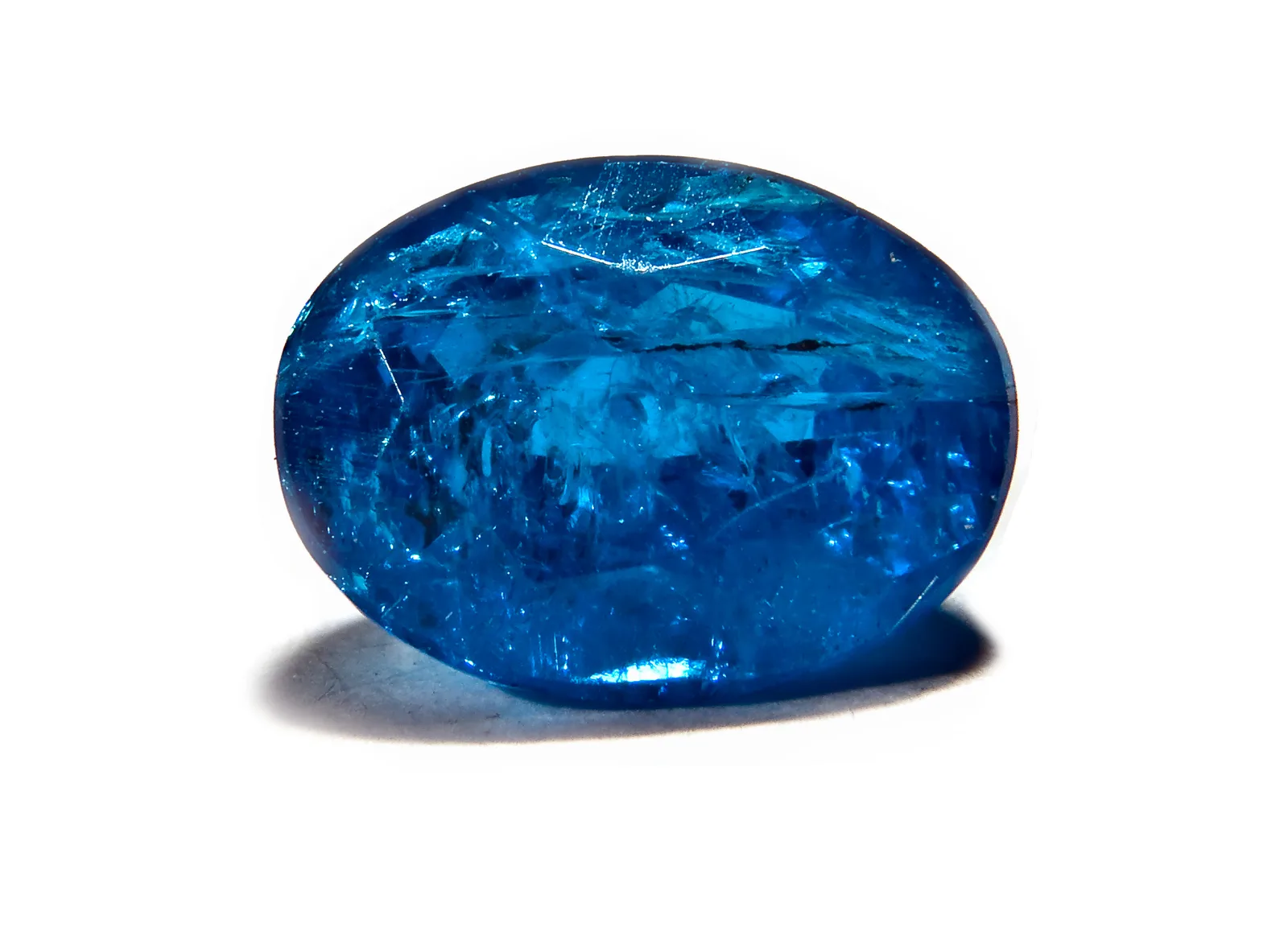 A faceted pear-shaped apatite, bright blue with green in the flashes, on a black ground