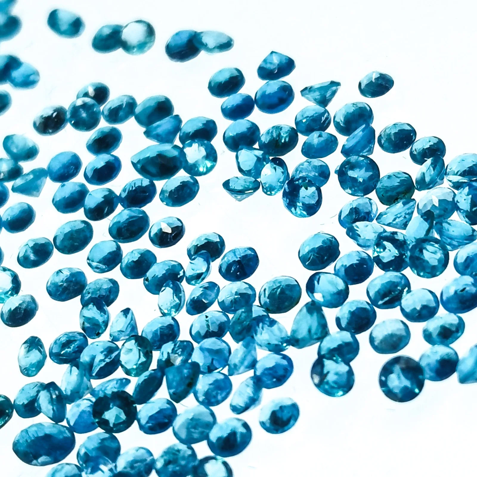 A round brilliant-cut blue apatite from Madagascar on a white ground