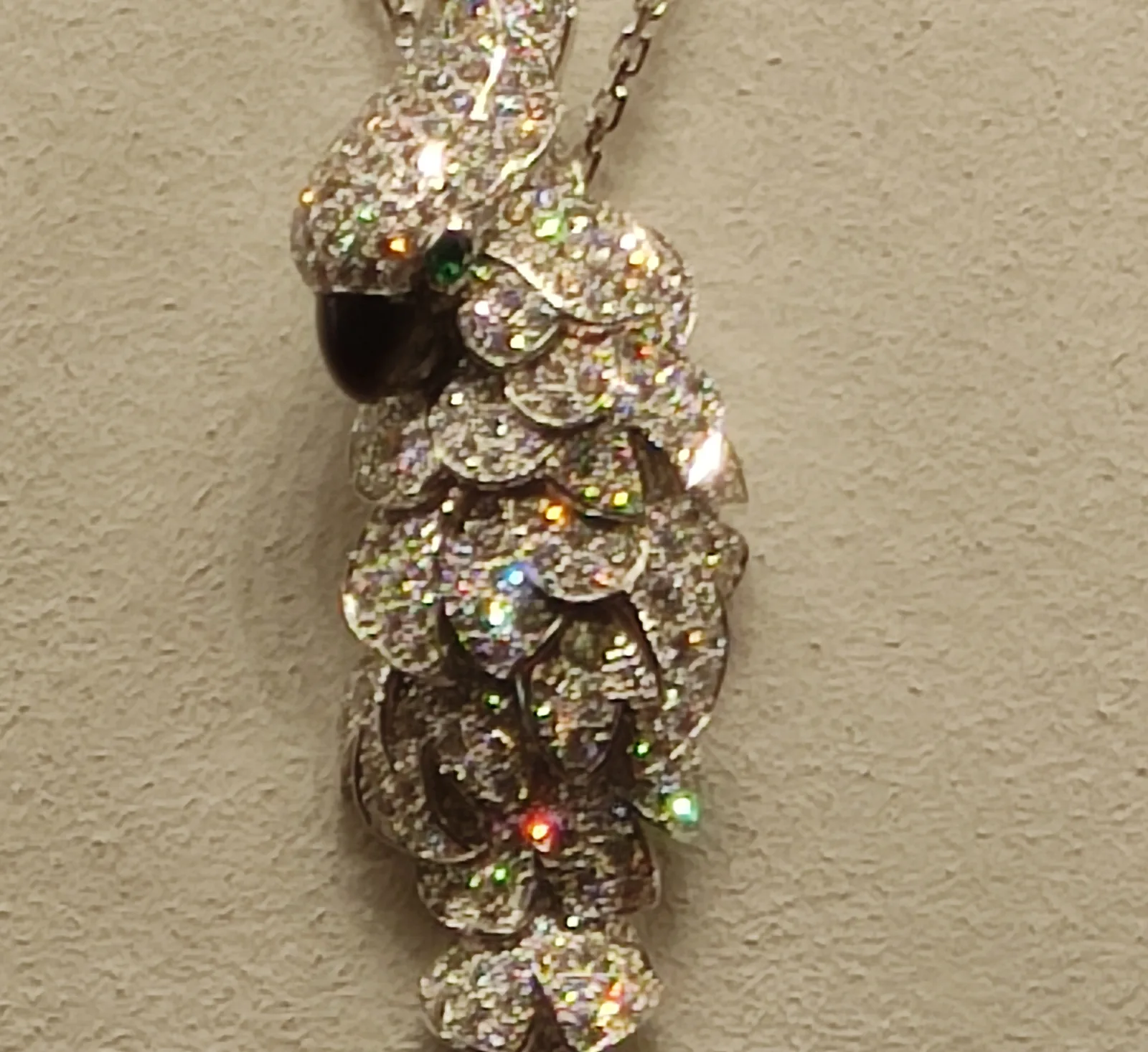 Two-tone Cartier Ballon Bleu with a diamond bezel and cabochon crown, shown off the wrist on a red cushion