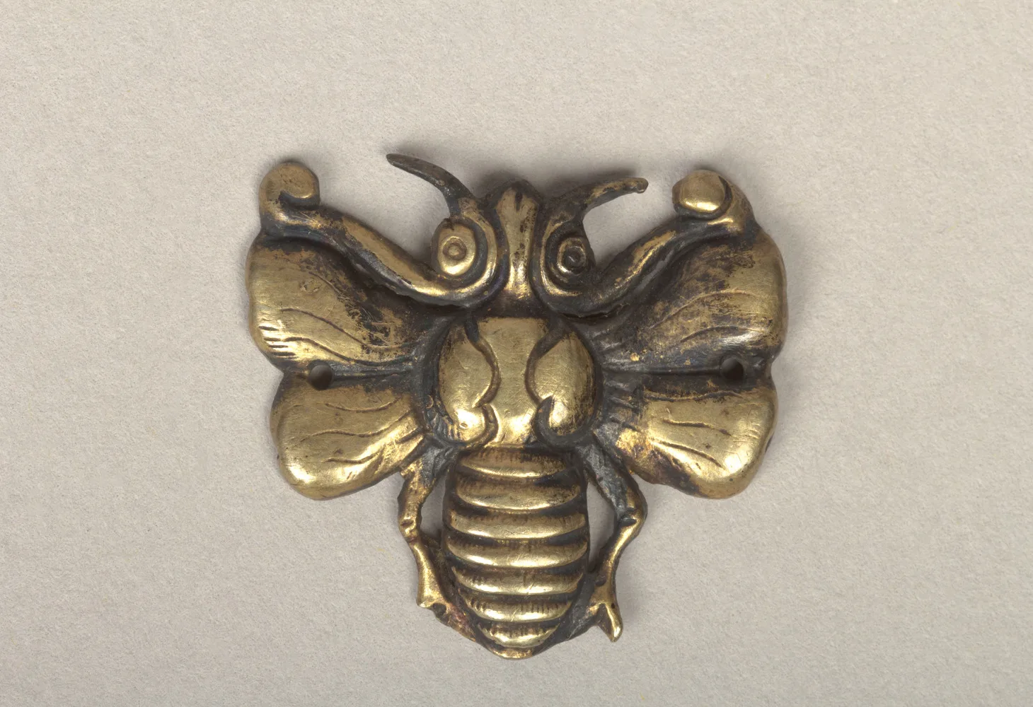 Goryeo gold ornament shaped as a bee with scrolled wing tips, ribbed abdomen, and two sew-holes in the wings