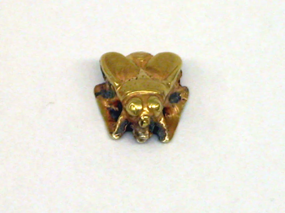 Javanese gold ornament in the shape of a bee with folded wings, large eyes, and a short sipping snout