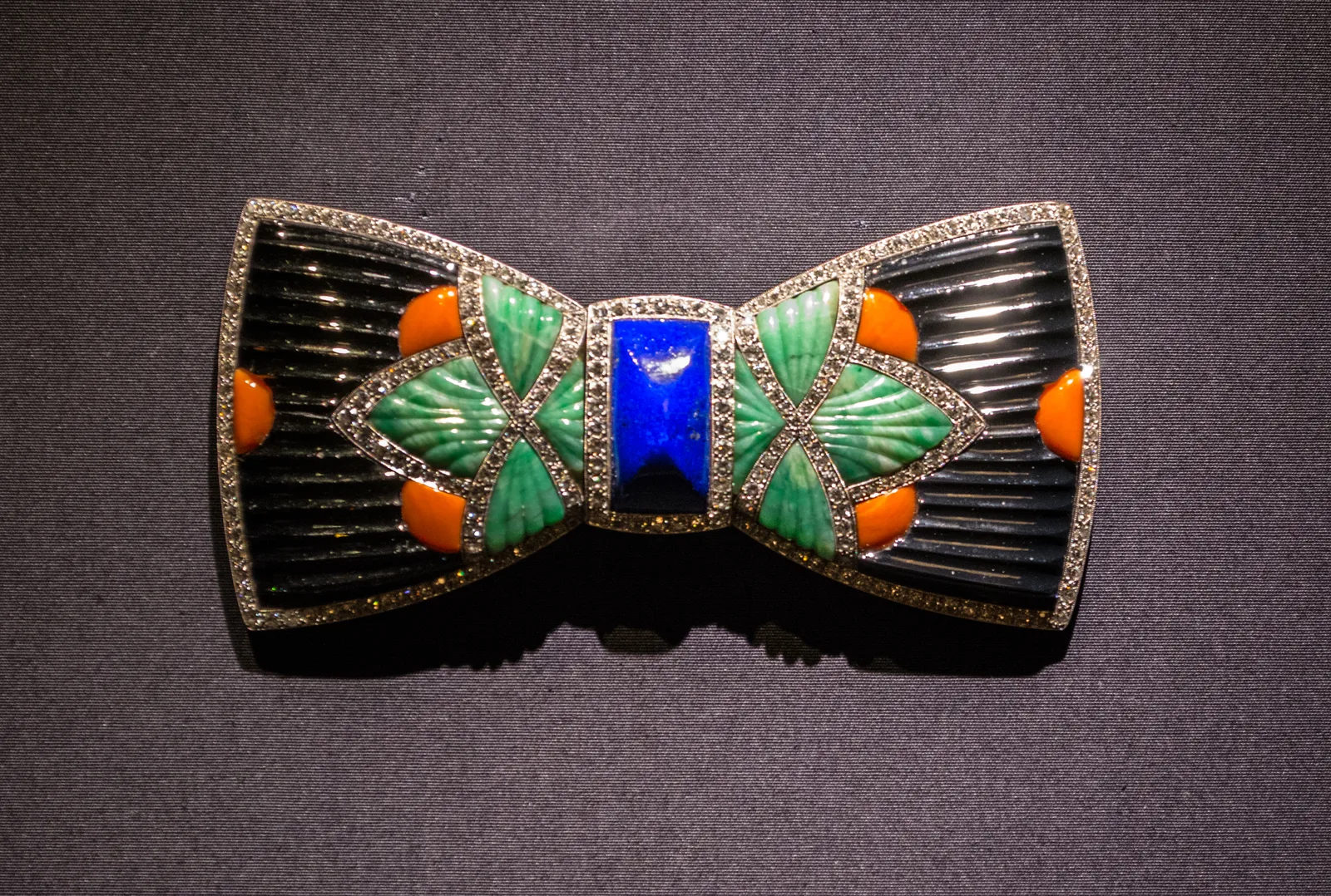 Boucheron Art Deco bow brooch of platinum, diamonds, carved lapis, onyx, coral, and jade