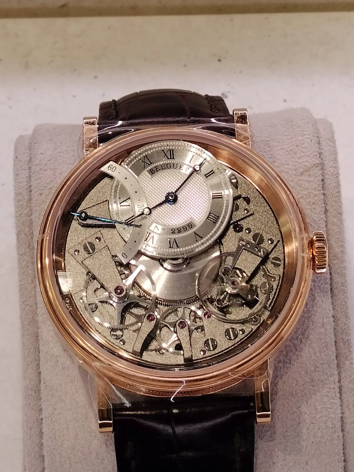Breguet Tradition reference 7097 in rose gold, openworked, with blued hands ending in hollow rings, shown off the wrist on a white ground