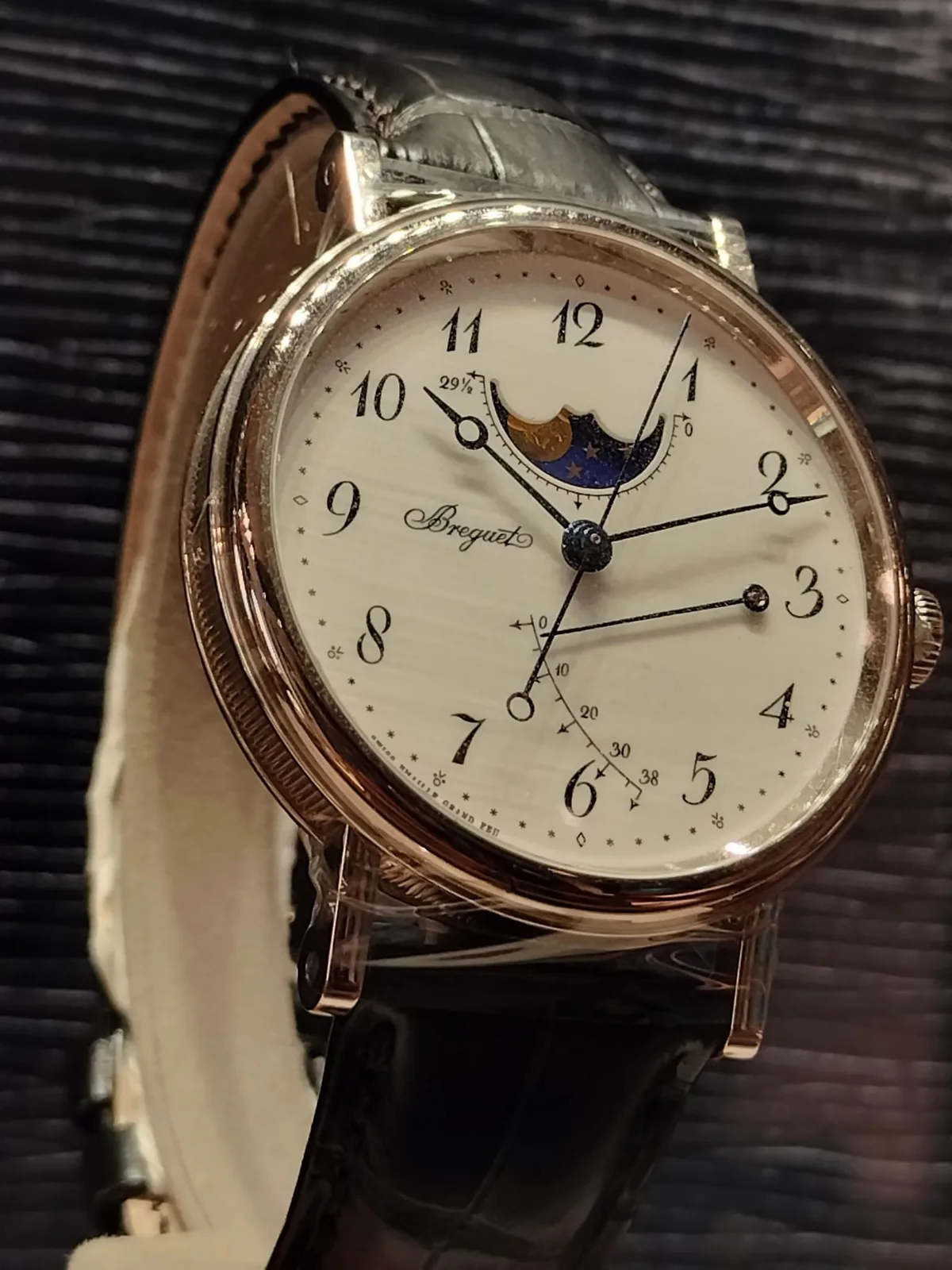 Breguet reference 7787 with a moonphase, a power-reserve subdial, Breguet numerals, and blued hollow-tipped hands, shown off the wrist