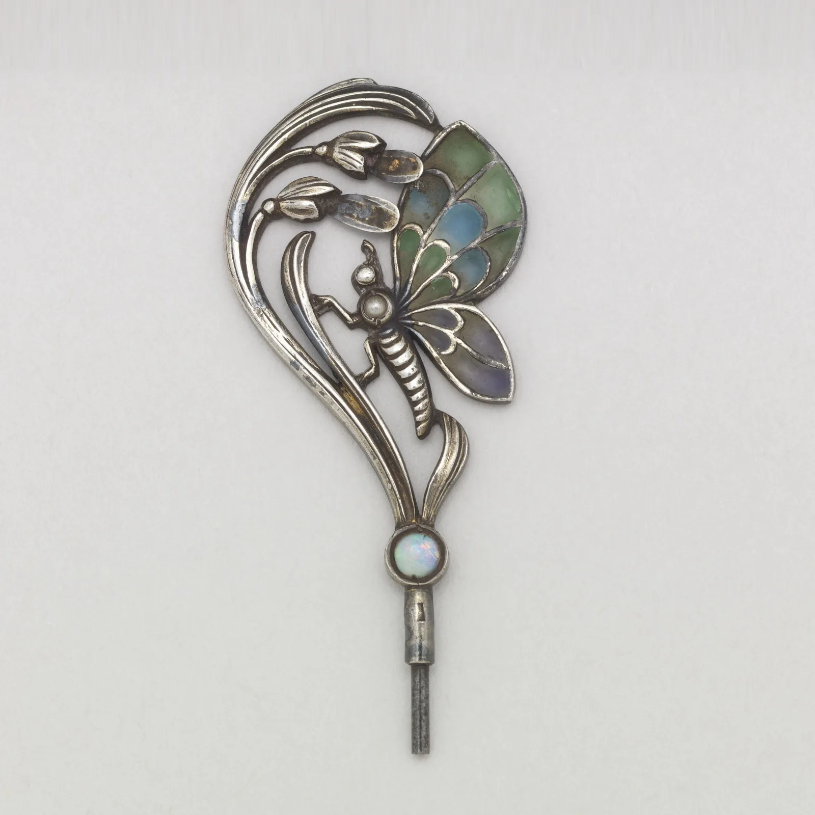 Art Nouveau butterfly stick pin finial with plique-à-jour enamel wings on a silver stem above an opal
