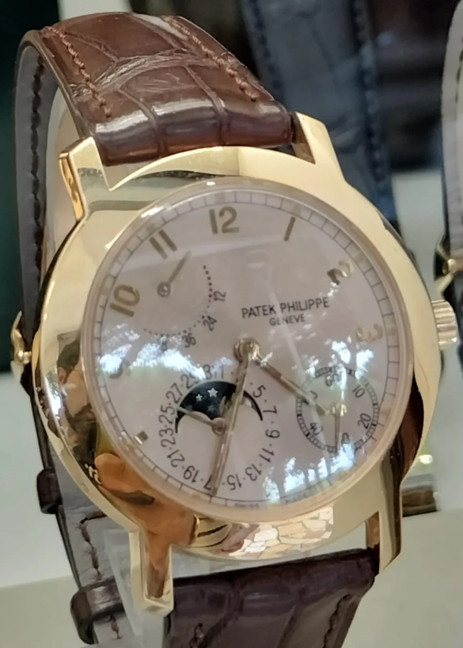 Patek Philippe Calatrava reference 5055 with a warm gold case and a hobnail bezel, shown off the wrist on a white ground