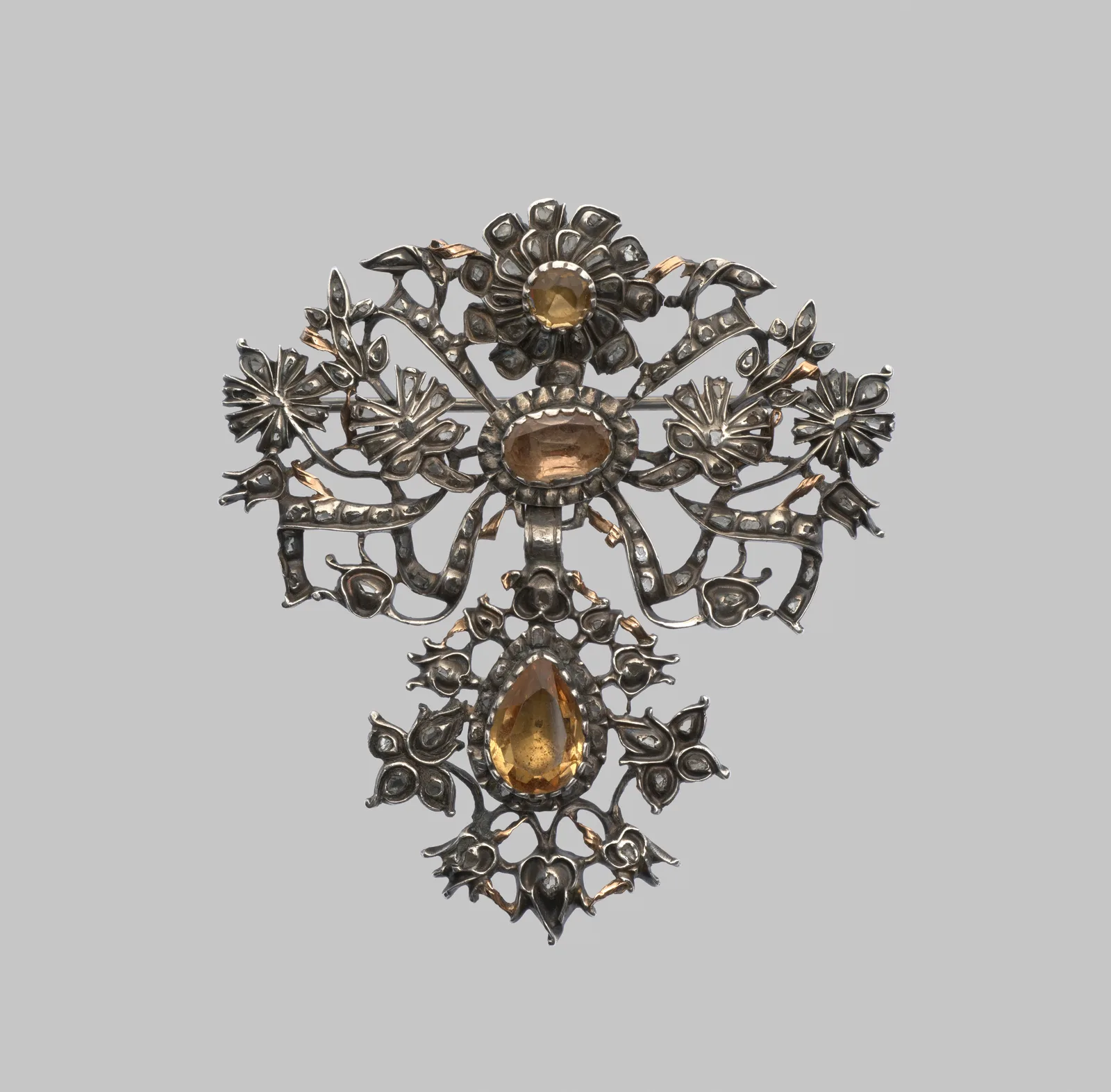Eighteenth-century silver and gilt floral brooch with a small round topaz, a larger oval topaz, a pear topaz drop, and small diamonds in the leaves
