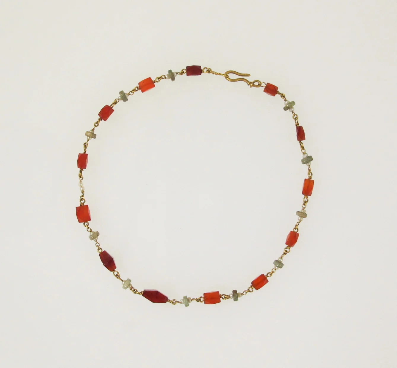 Roman necklace of warm orange carnelian beads linked with gold, arranged in a circle