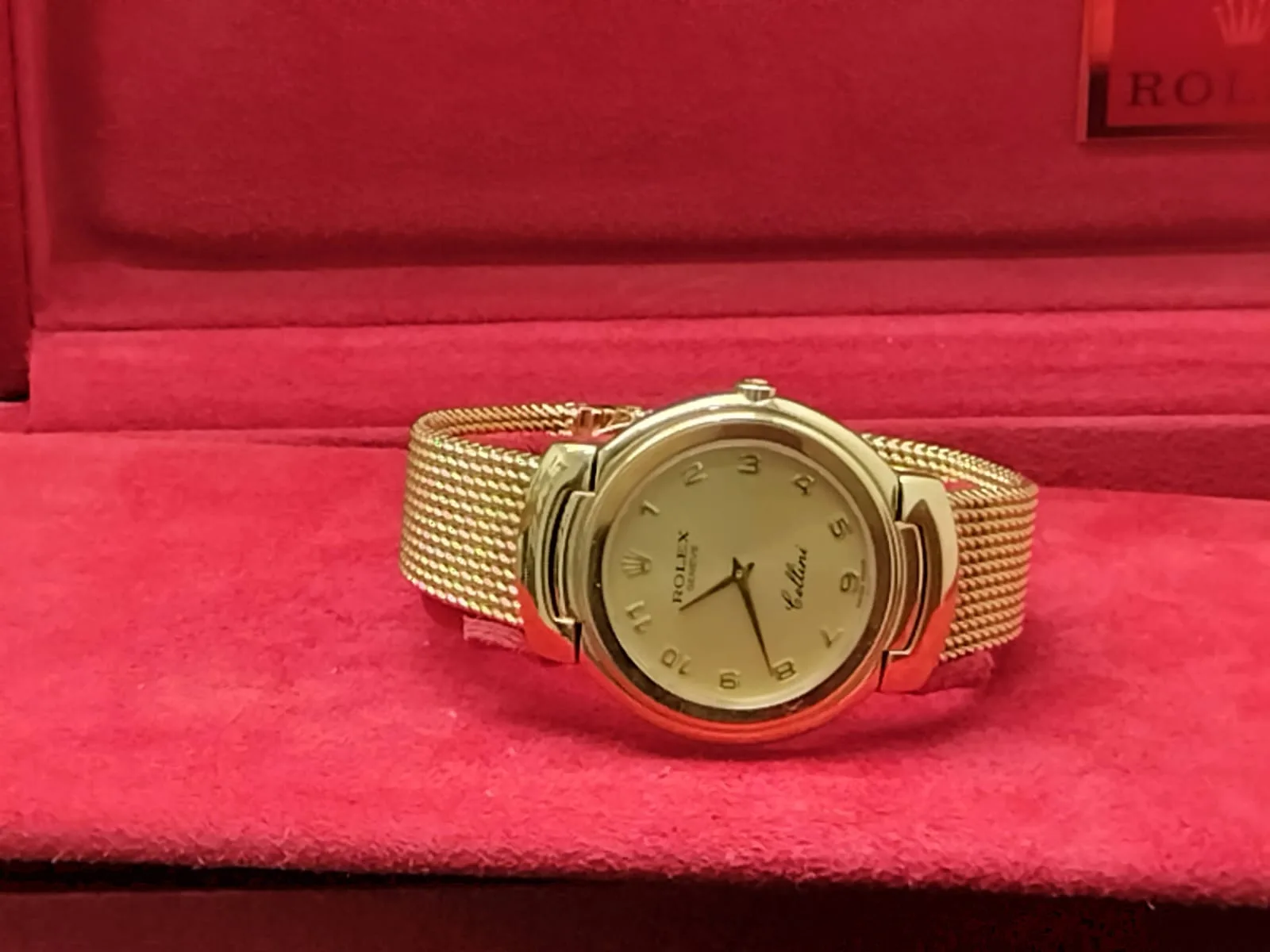 Rolex Cellini reference 6623 in yellow gold with a black dial, shown off the wrist on a display stand