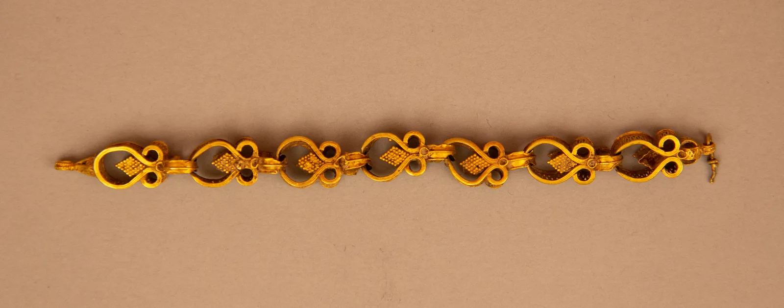 Fourteenth-century gold chain of open scrolled oval links, each loop already a hold for the next