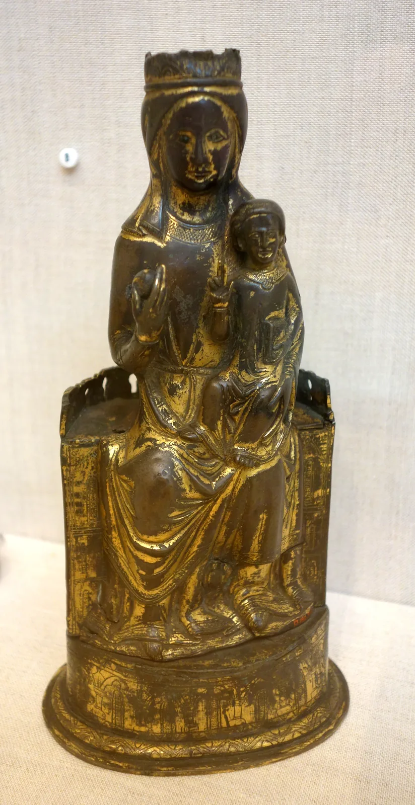 A gilt-copper Virgin and Child with champlevé enamel, Limoges, about 1300, on a white ground