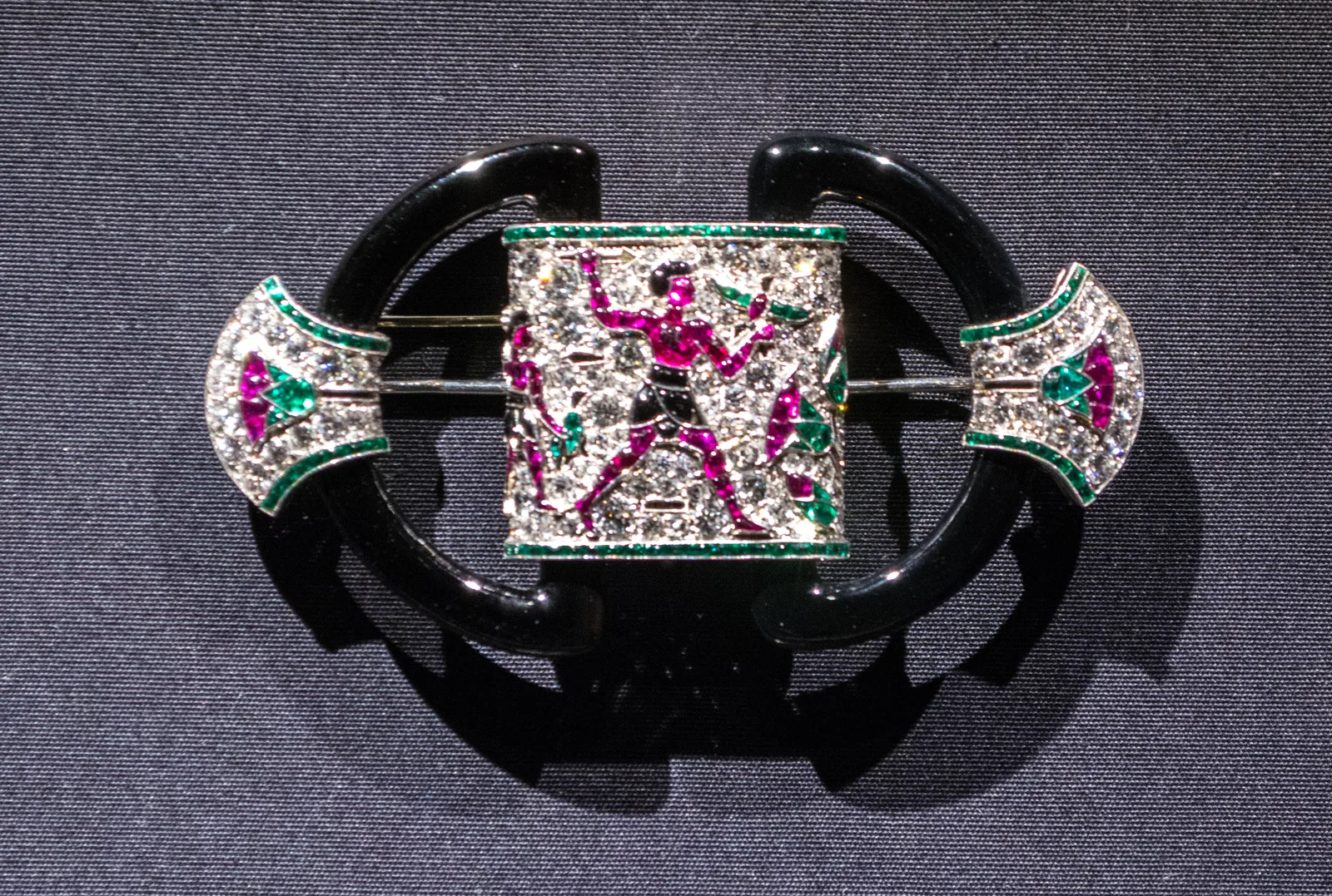 Chaumet Egyptian revival brooch with a diamond field, ruby and emerald lotus motifs, and curved onyx sides