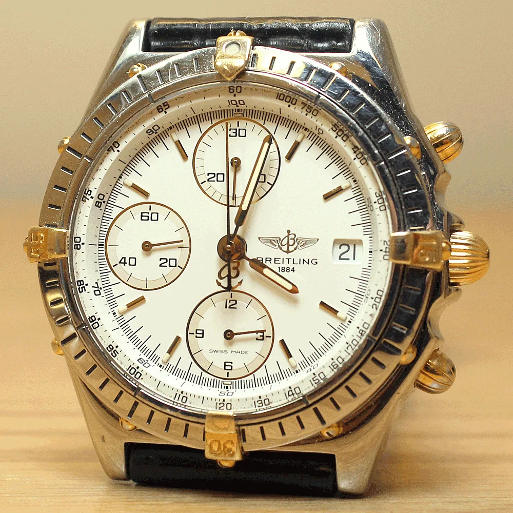 A two-tone Breitling Chronomat with a white dial and four bezel tabs, shown off the wrist