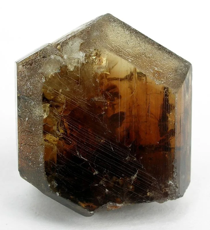 A glassy yellow-green chrysoberyl twin from Santa Teresa, a single sharp crystal on a white ground