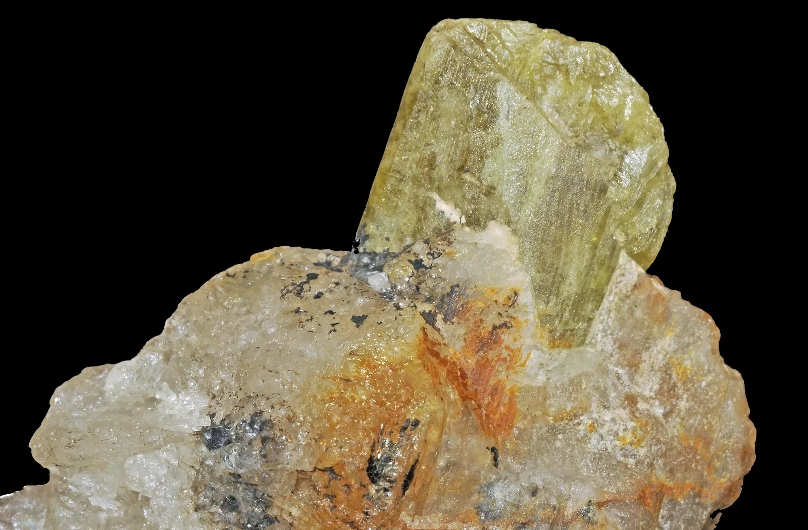 A yellow-green chrysoberyl trilling, a flat cyclic twin on a white ground