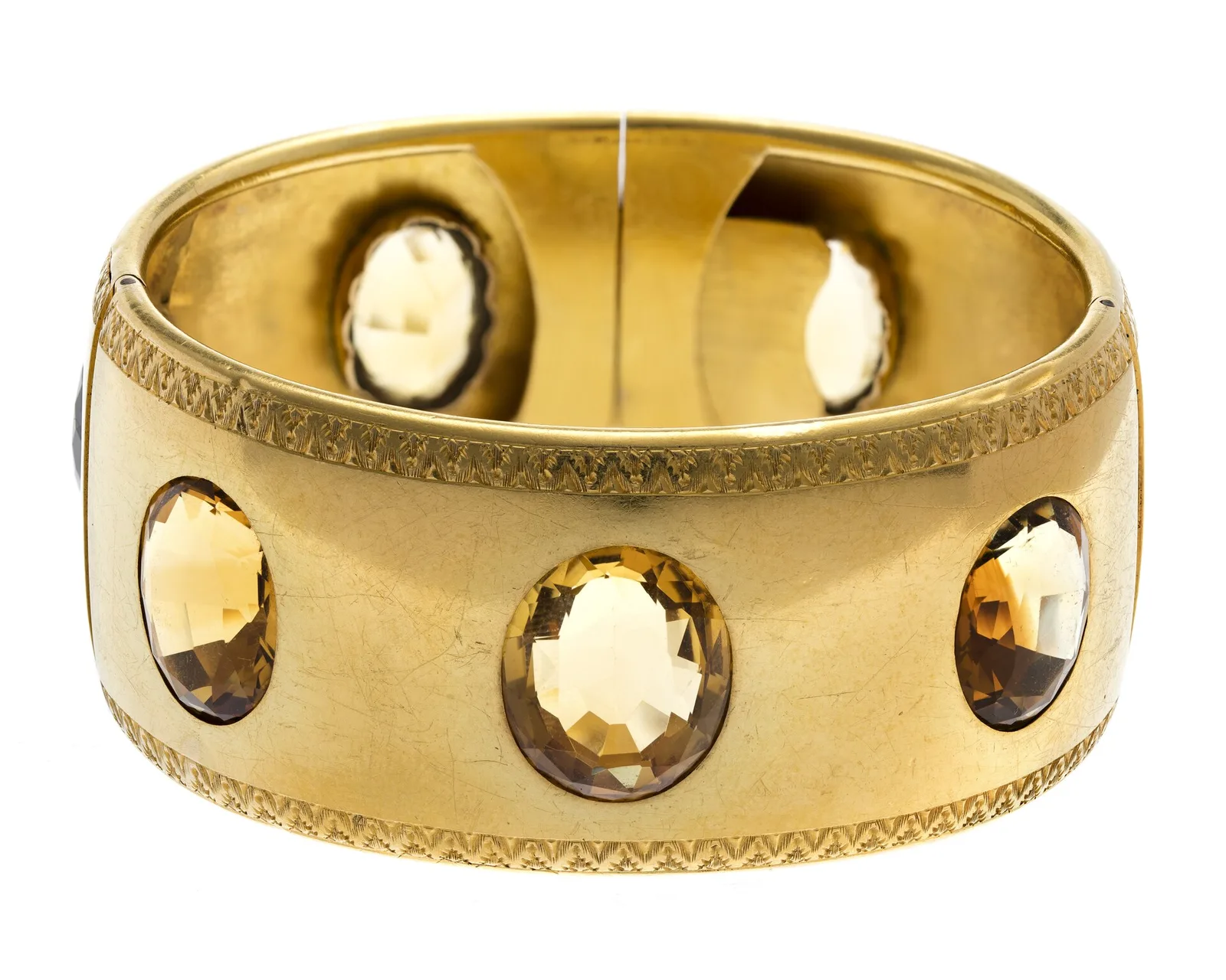 Wide nineteenth-century gold bangle set with oval honey-yellow topazes around the band and a fine engraved rim