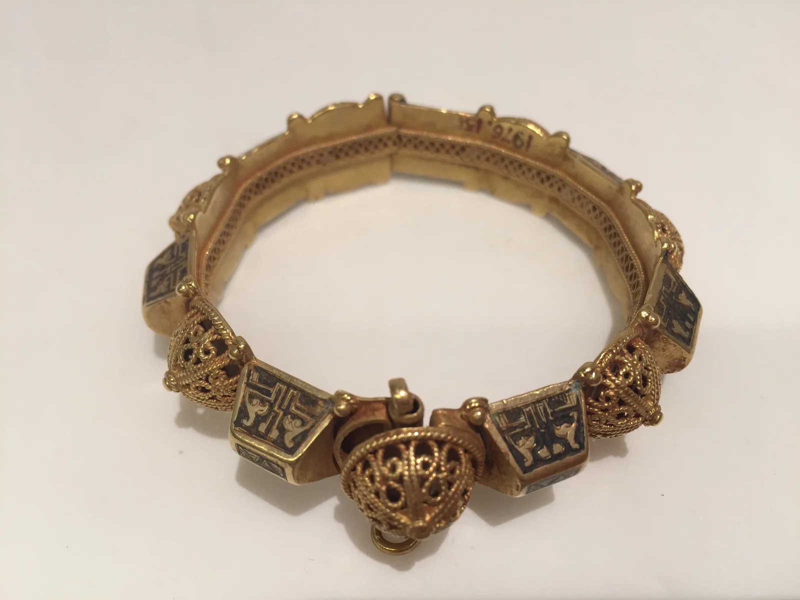 Twelfth-century gold bracelet of alternating filigree domes and niello-inlaid blocks, the domes standing as granulated bosses around the hoop