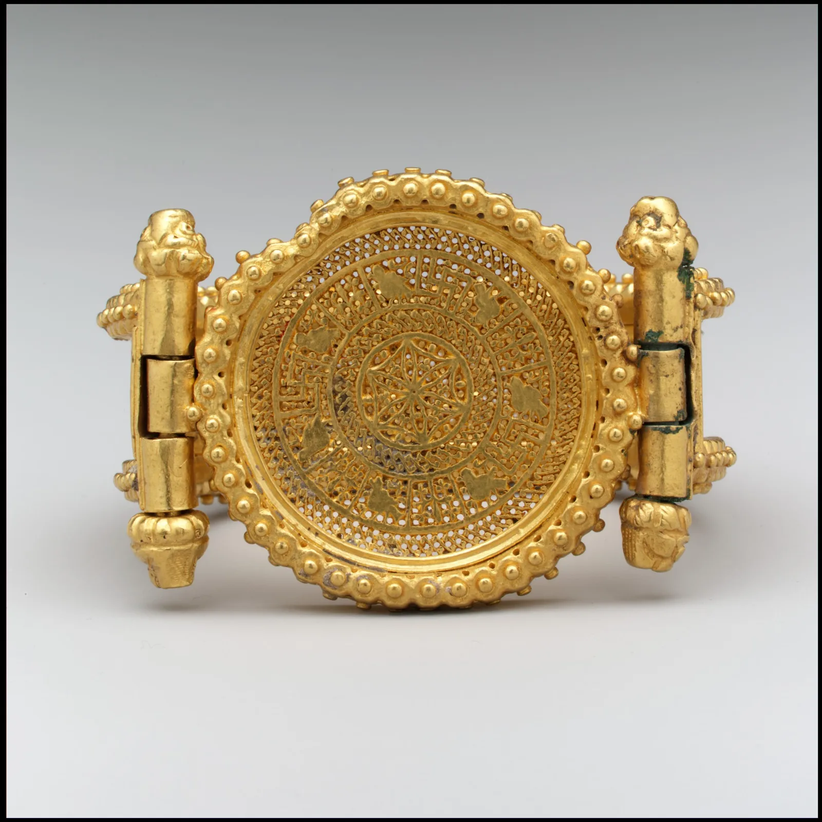 Byzantine hinged gold cuff with a circular granulated medallion and a wide strap densely covered in gold granules
