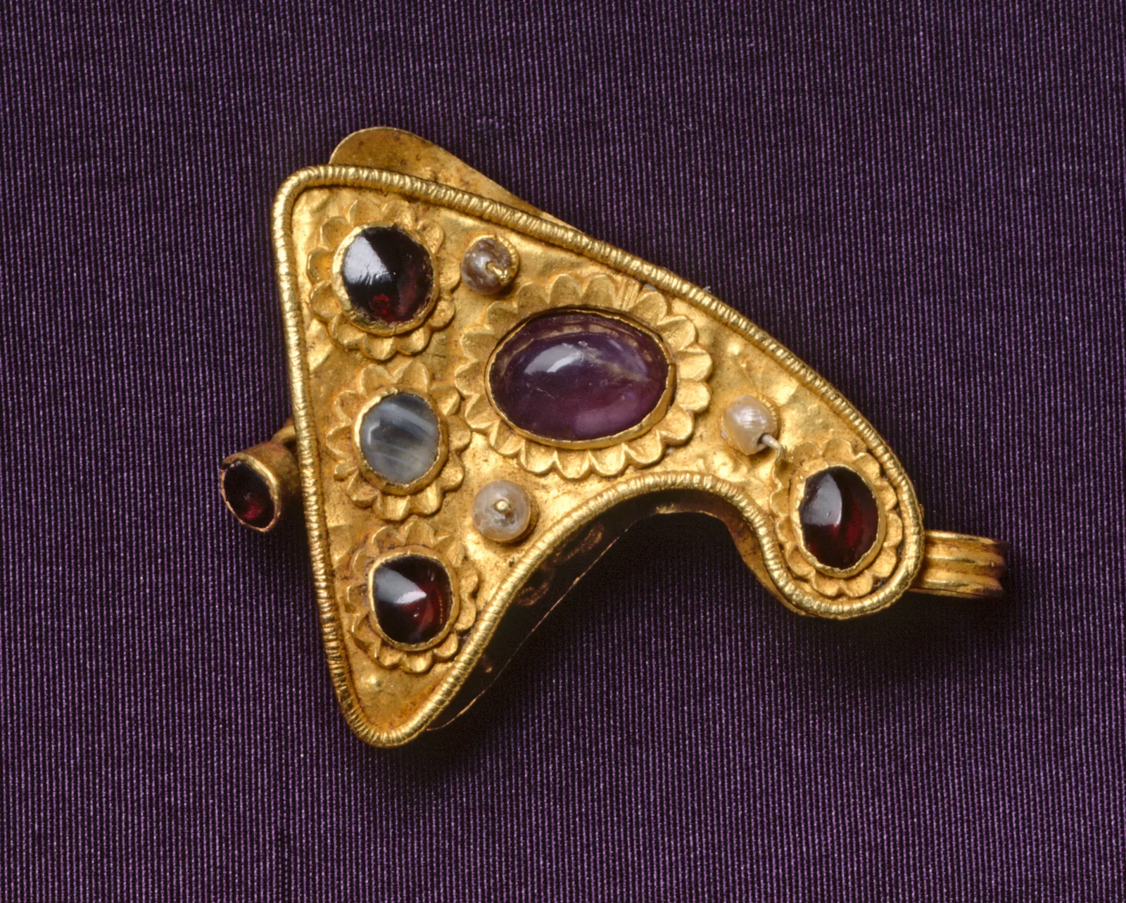 Late Roman gold clasp plaque set with amethyst, garnets, pearls, and banded stone, a pin as the close at one side