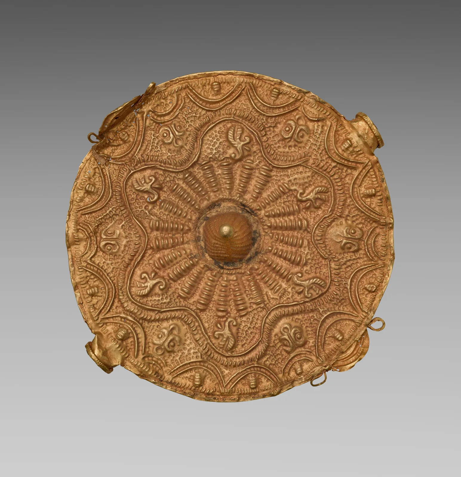 Asante gold disk pendant with a raised central boss, radiating ribs, and a scalloped embossed border