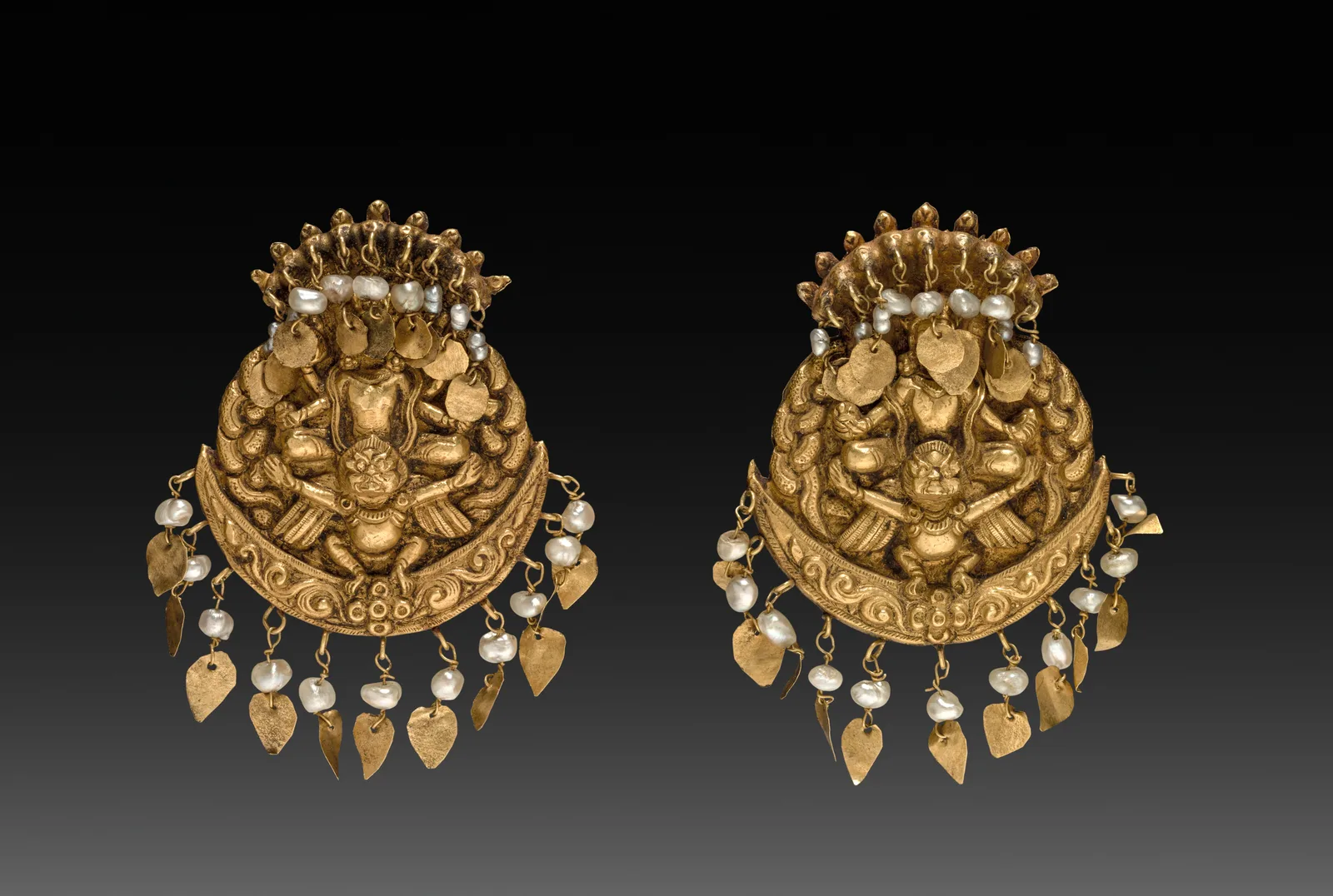 Pair of Nepalese gold earrings in high relief with seated figures, pearl fringes, and small gold leaf drops