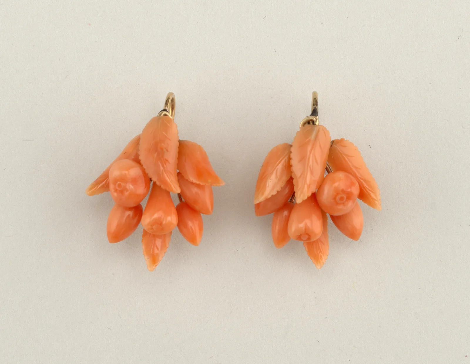 Pair of Italian earrings, each a small spray of carved coral leaves and berries on gold stems