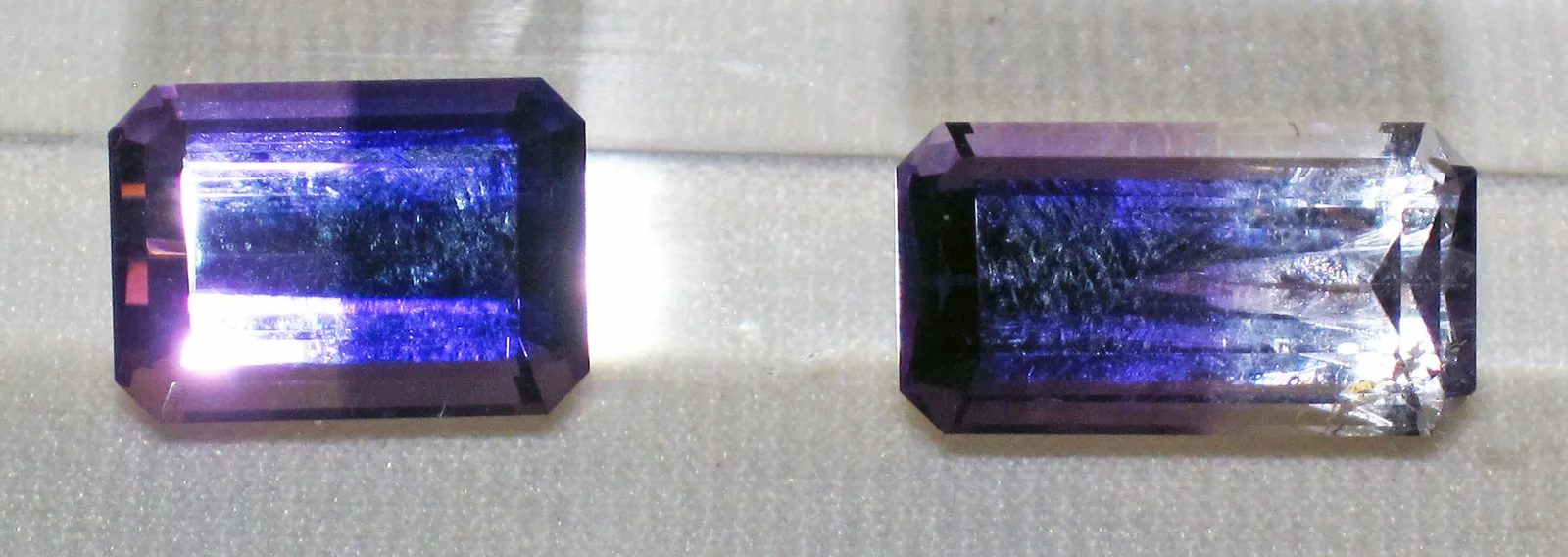Two faceted amethysts seen from the side, each with a crown of facets above the girdle and a pavilion below