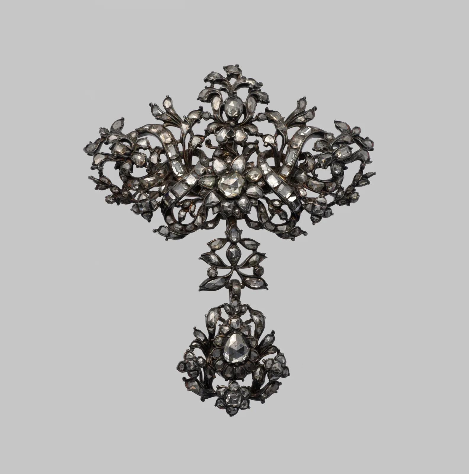 Early eighteenth-century silver bow brooch densely set with old-cut diamonds, a floral knot at the center and a diamond drop below