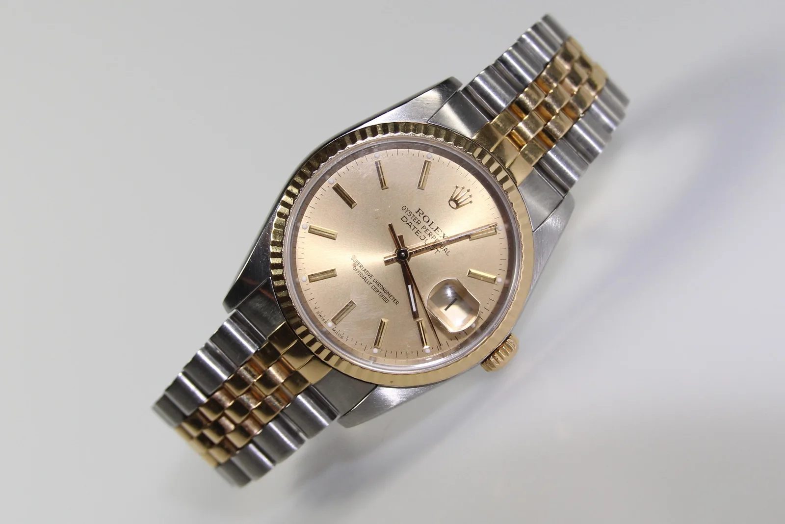 Two-tone Rolex Datejust with a champagne dial, fluted gold bezel, and Jubilee bracelet