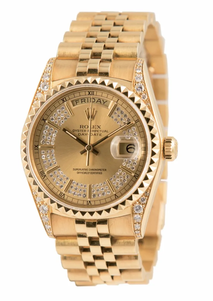 Yellow-gold Rolex Day-Date with a President bracelet, a fluted bezel, Monday in the day window, and a date under the cyclops, shown off the wrist on a white ground
