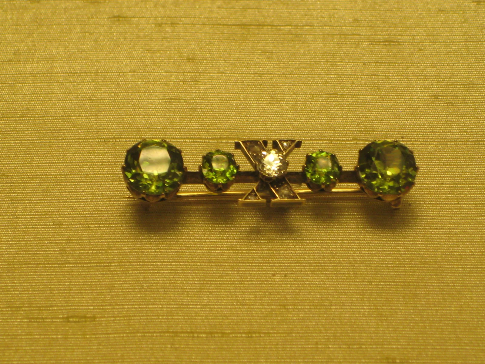 A Russian gold cross brooch by A. Tillander with a central brilliant and arms set with demantoid garnets and diamonds