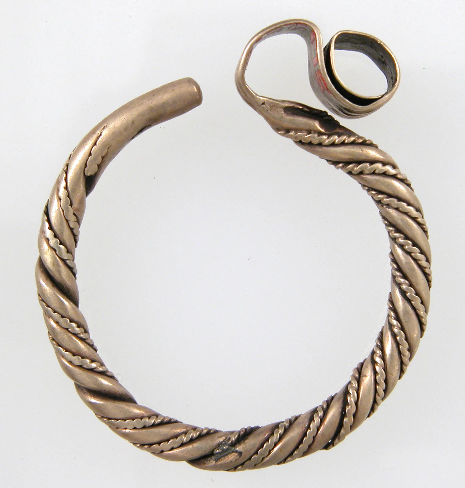 A Viking electrum lunula earring, a pale crescent with a hook above and a small loop below