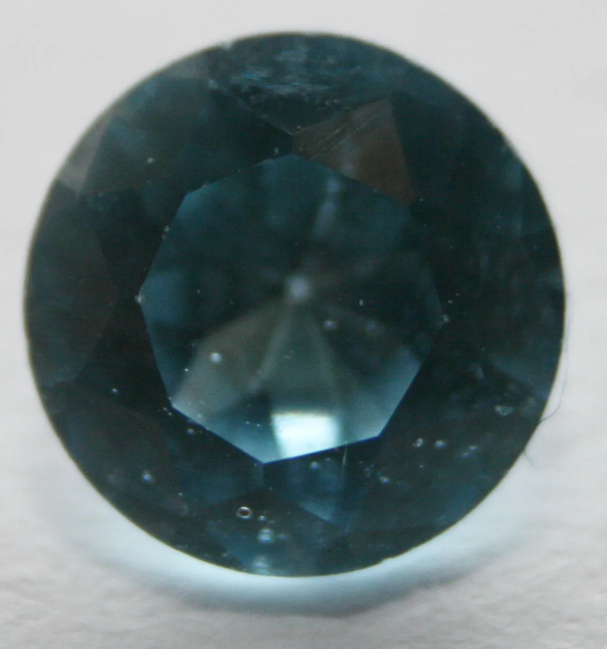 Round blue topaz brilliant seen from above, the crown a set of flat facets around the center
