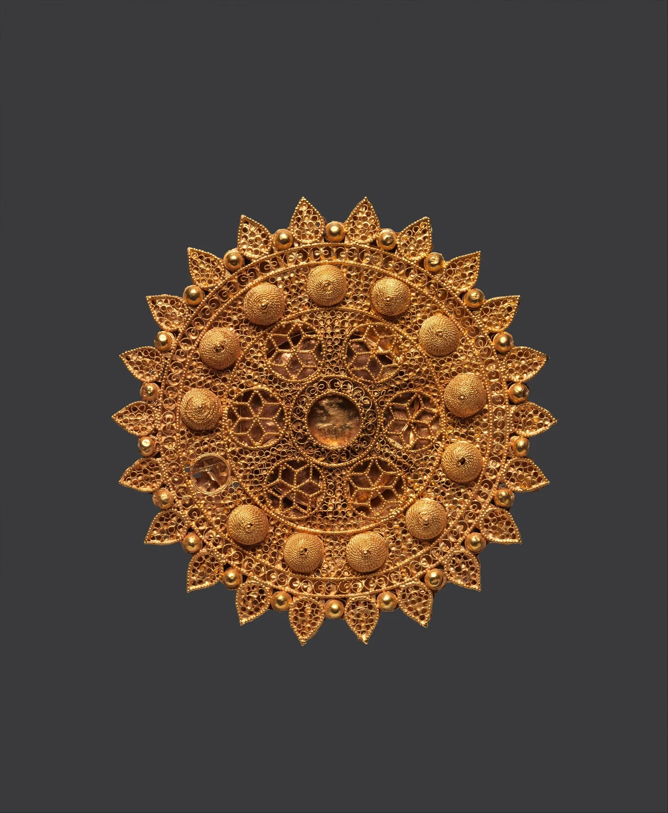 Eleventh-century gold roundel of radiating filigree points, raised wire domes, and an openwork star lattice at the center
