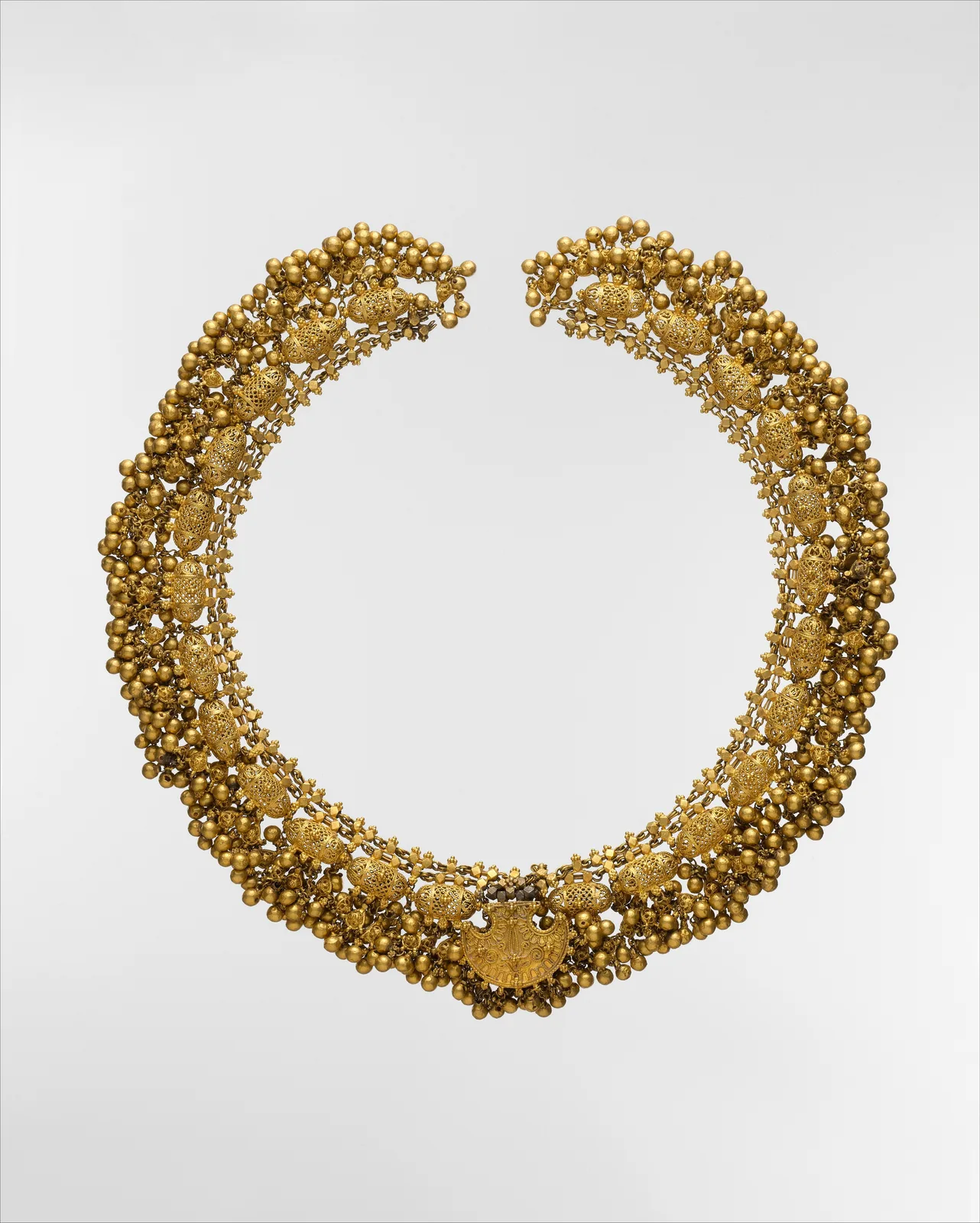 Indian gold necklace of openwork filigree beads with clusters of granulation and a small central pendant