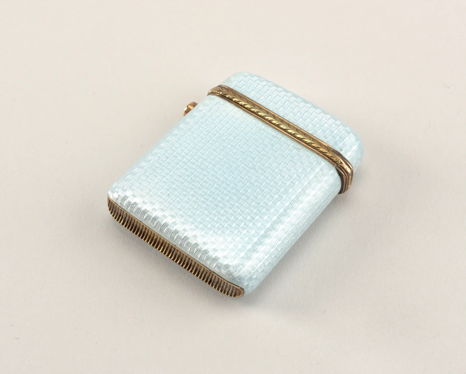 A Fabergé matchsafe with pale blue enamel over a wavy engine-turned ground and a gold acanthus border