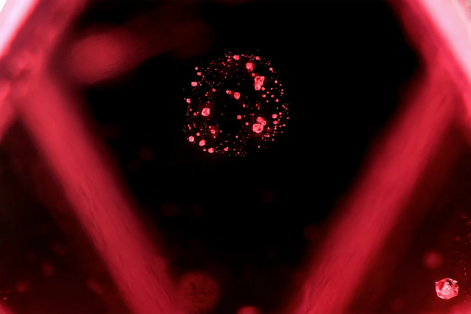 A spherical cluster of tiny crystals inside a gem spinel, seen close