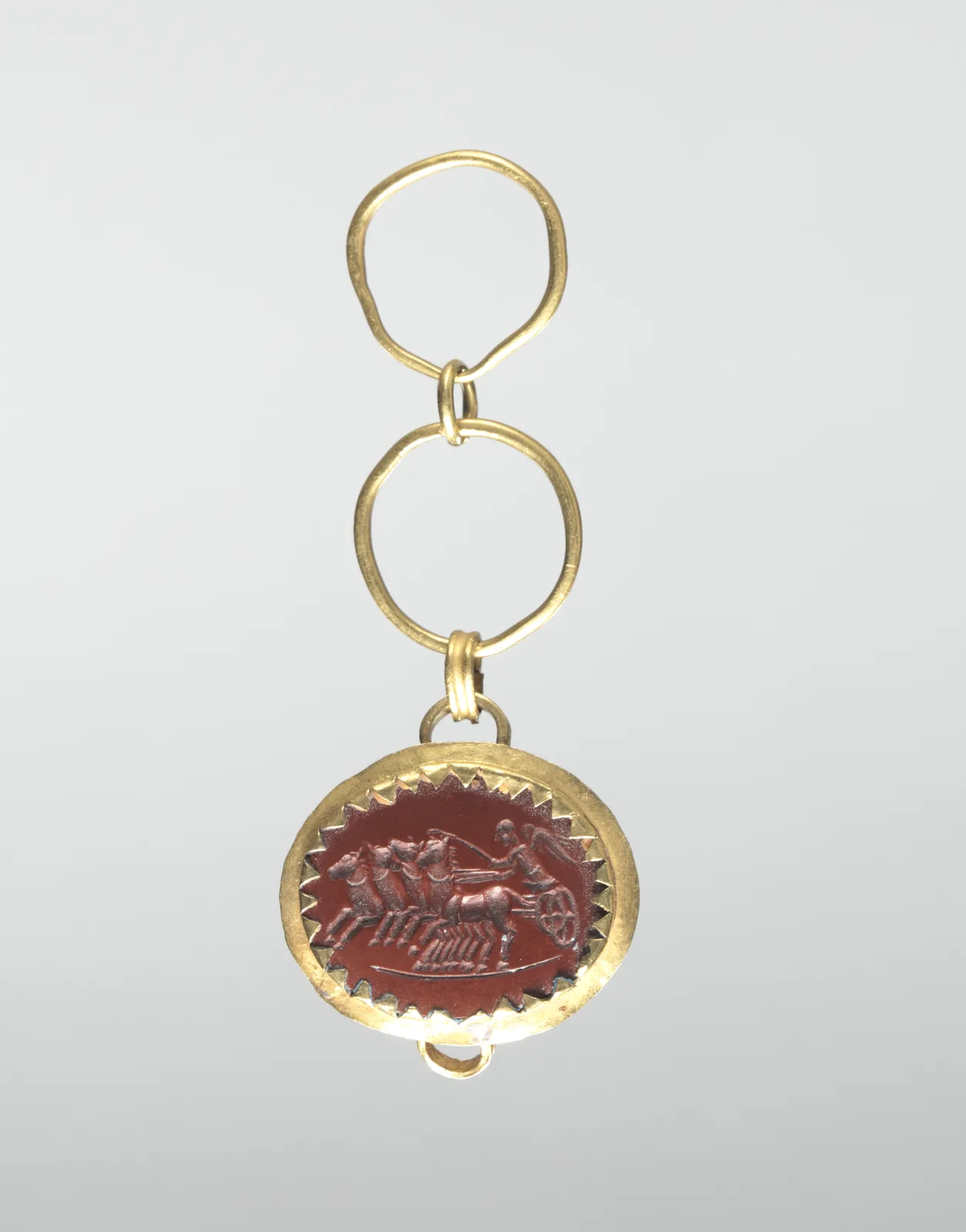 Roman red-jasper intaglio of Victory in a chariot, set in a toothed gold mount with a loop