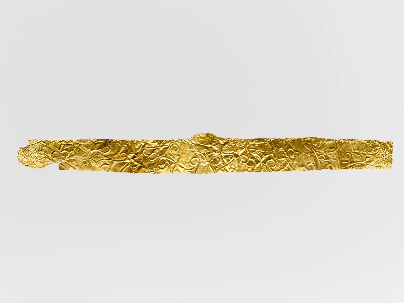 Cypriot gold diadem as a thin horizontal sheet of gold embossed with scrolling palmettes and vines