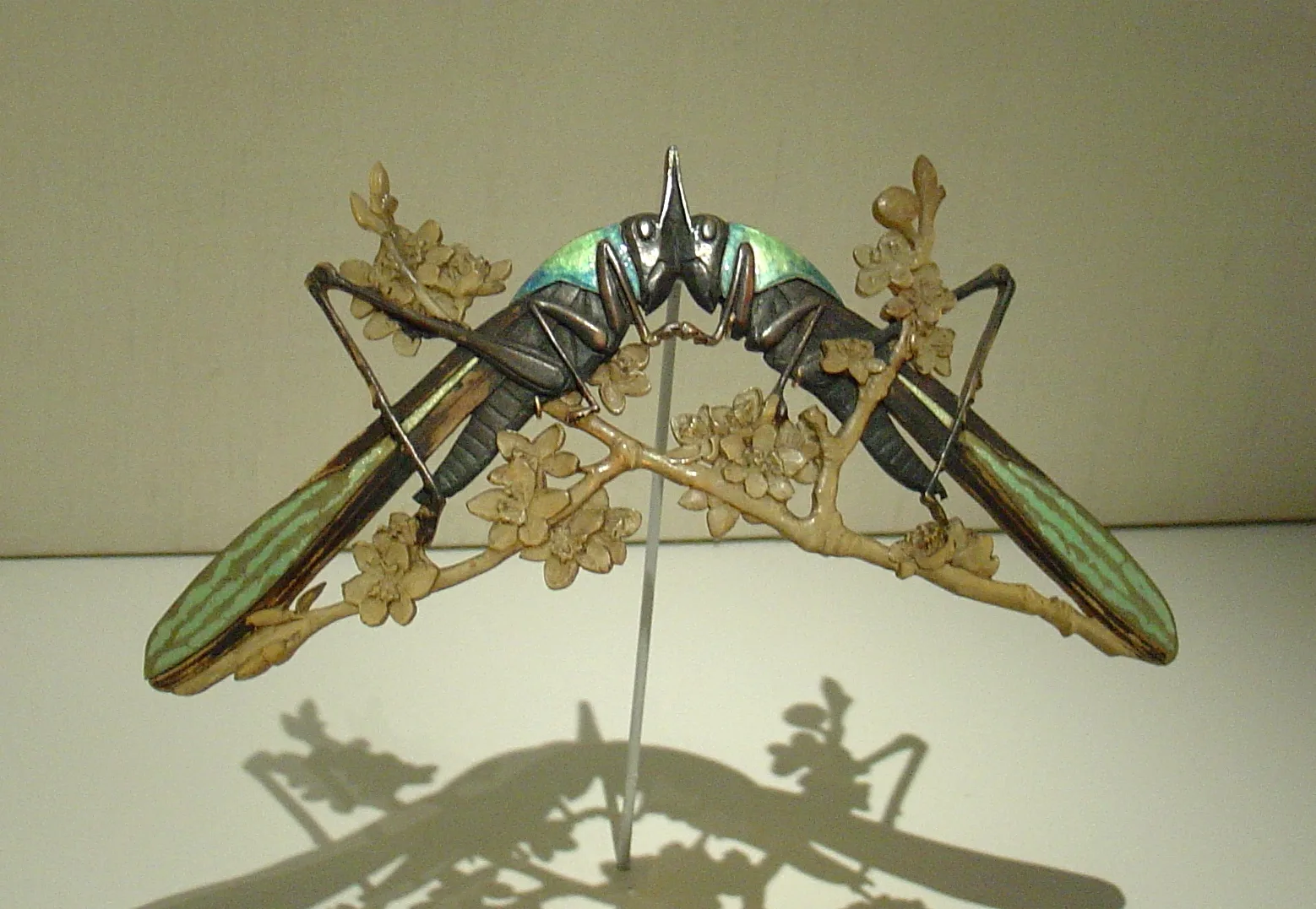 René Lalique cicada ornament with iridescent enamel wings on a carved flowering branch