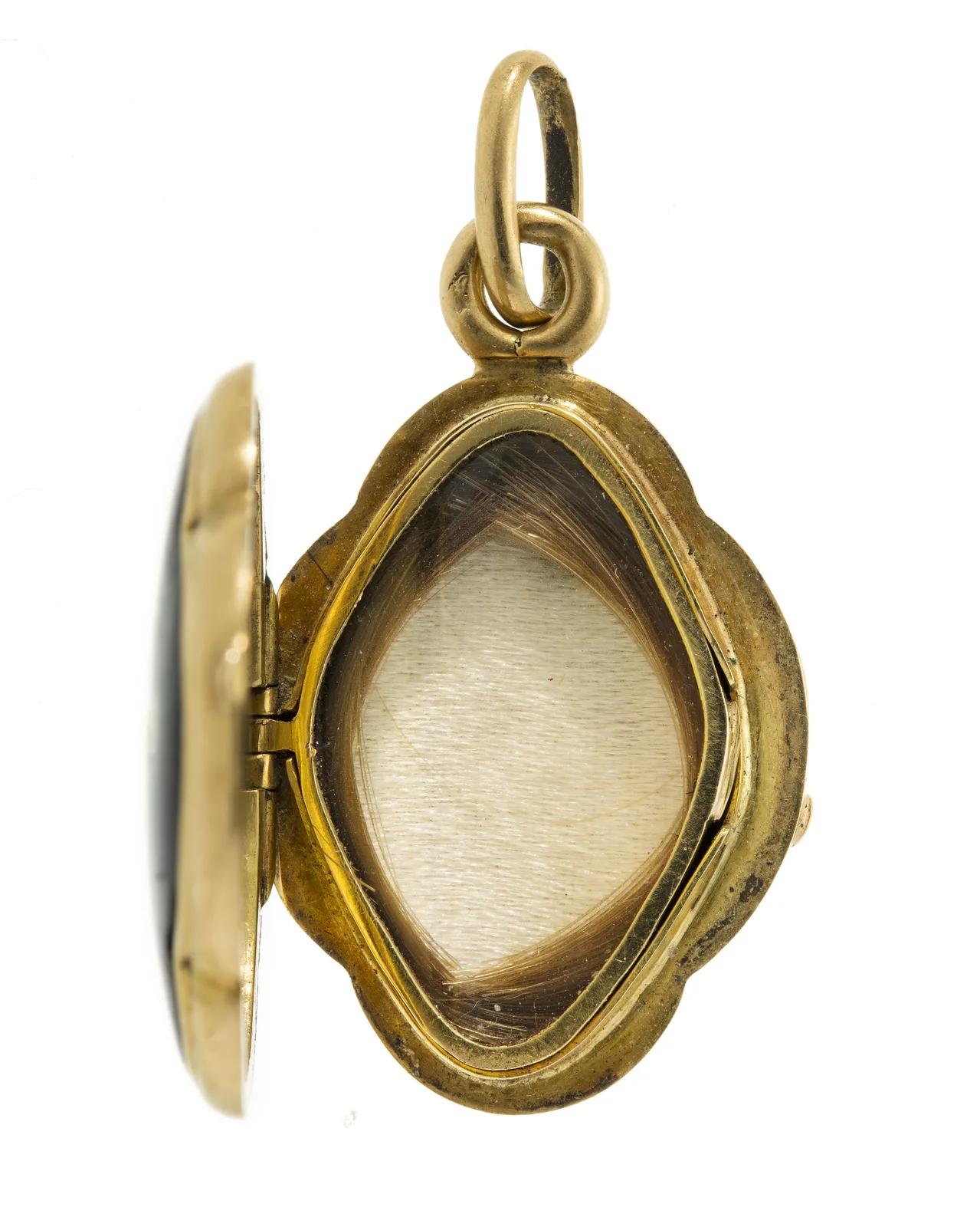 Nineteenth-century locket interior, a compartment of woven hair under glass in a shaped metal reserve