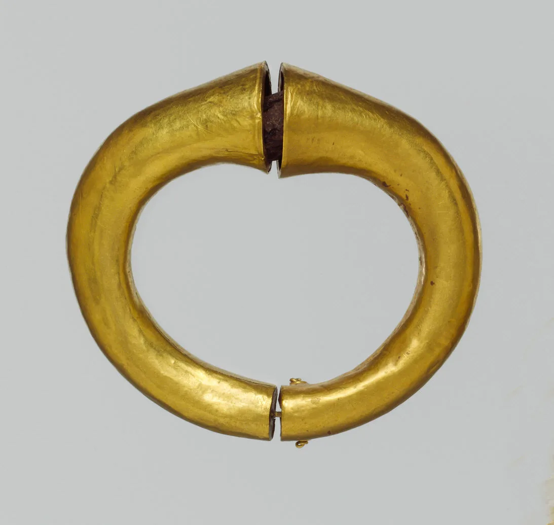 Ancient gold hinged armlet formed as a rigid tubular oval with a hinge at one side and a closing joint at the other