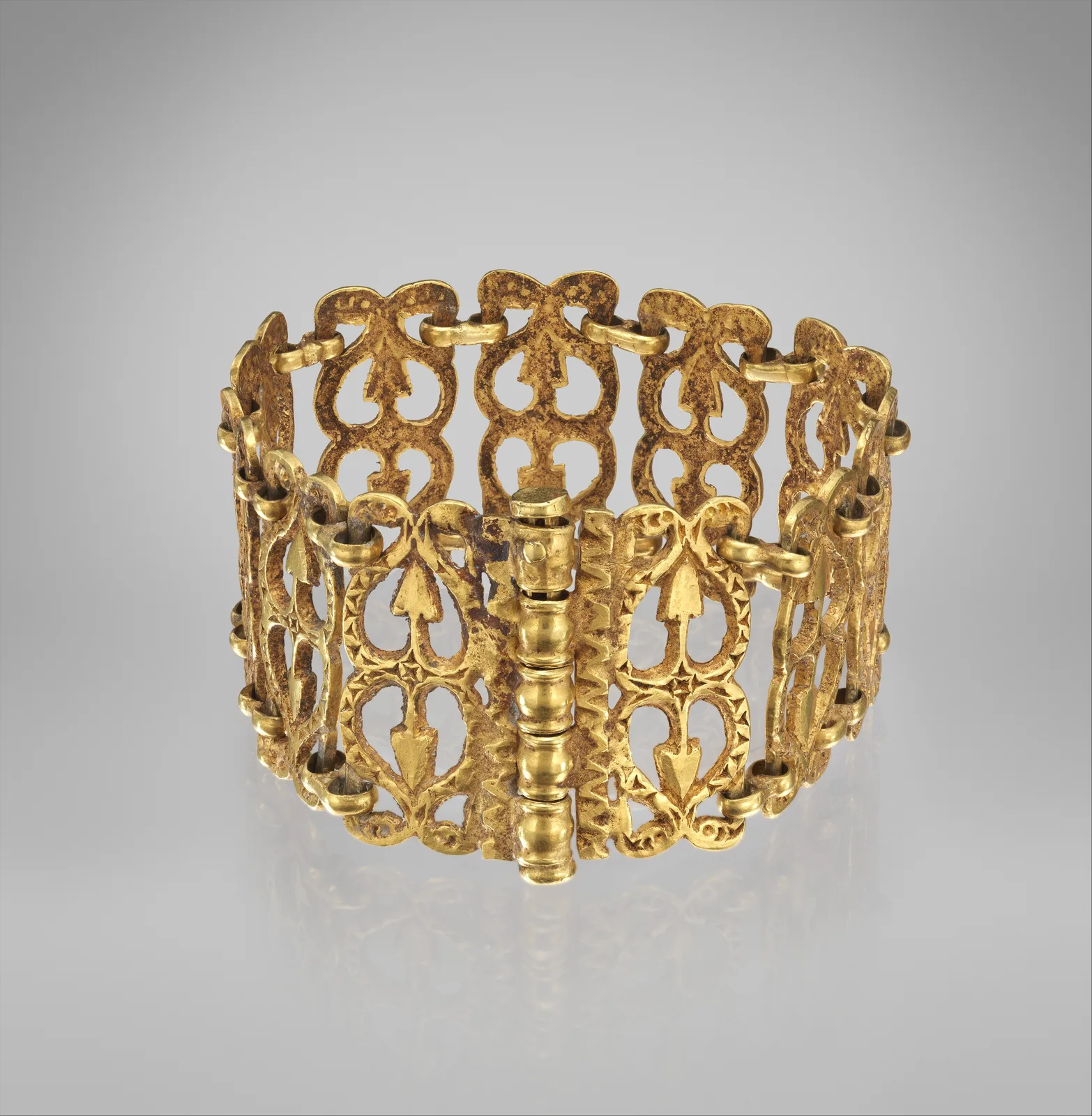 Byzantine gold bracelet of pierced ivy-leaf panels joined as a rigid oval, with a stacked barrel hinge and pin at the front