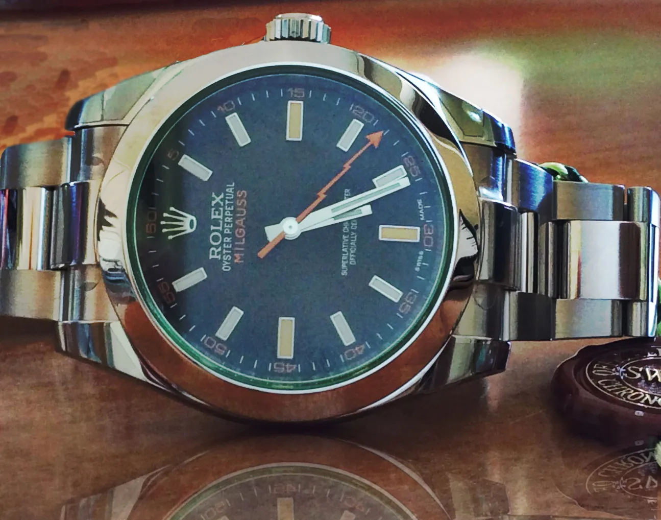 Rolex Milgauss ref. 116400GV with a blue dial and an orange lightning seconds hand, shown off the wrist on a white ground
