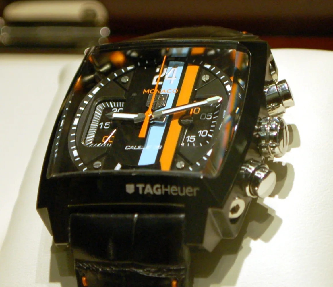 TAG Heuer Monaco 24 with a square black case and an open view of the movement, shown off the wrist