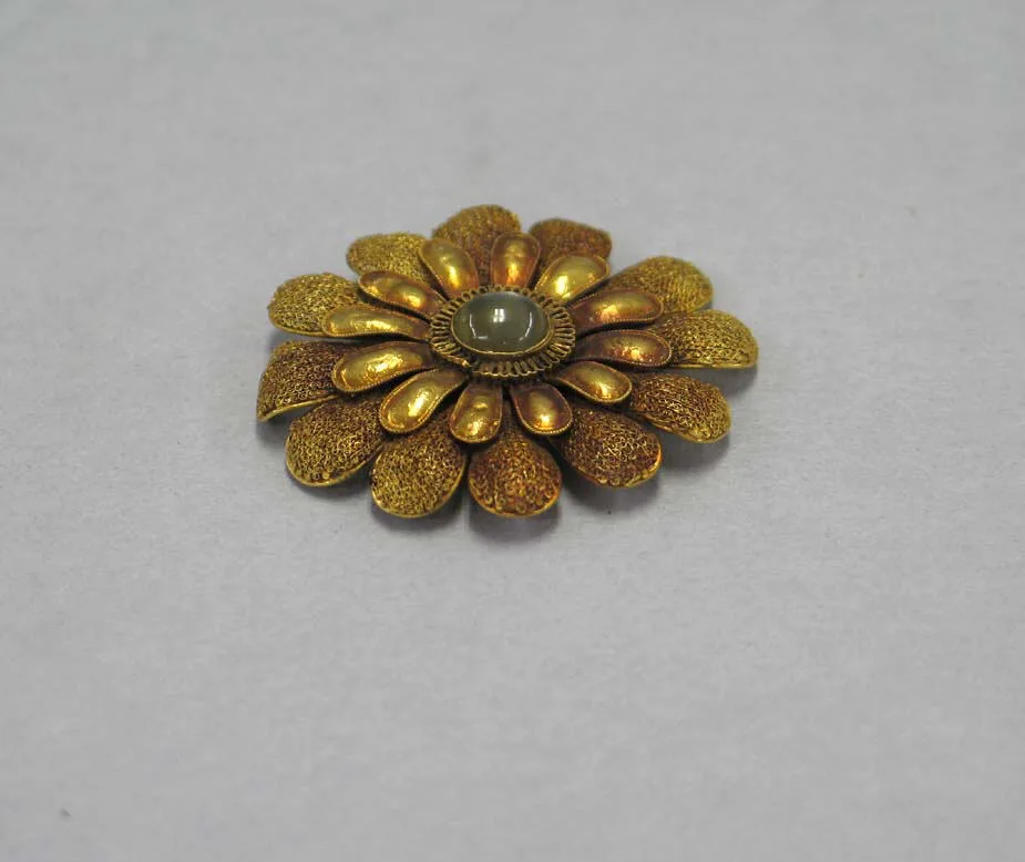 Song-dynasty gold floral ornament with two rings of petals and a milky moonstone cabochon at the center