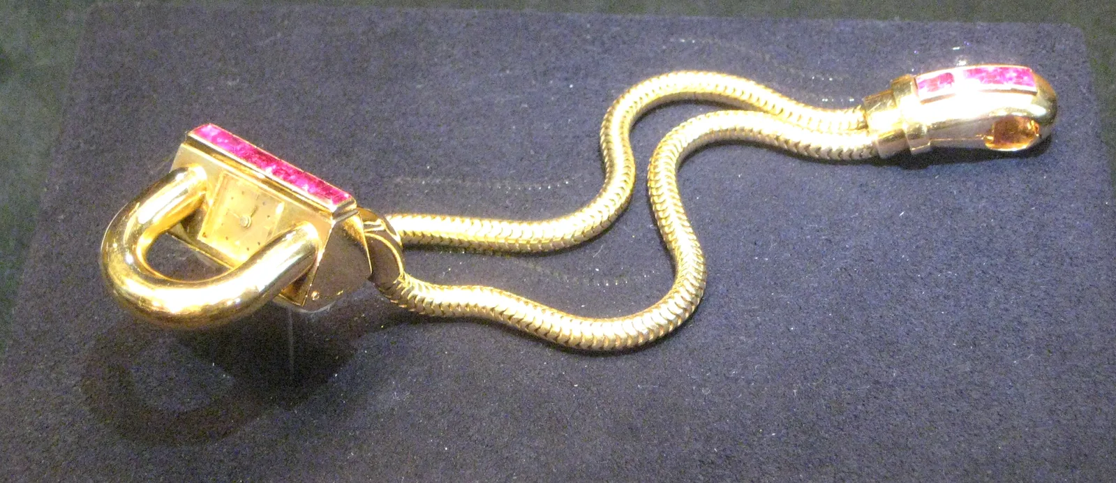 Van Cleef & Arpels Cadenas watch in yellow gold with a flush row of mystery-set rubies on the case and clasp